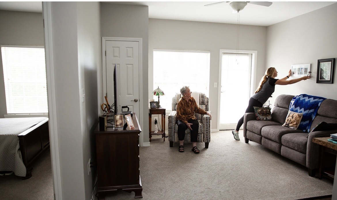 Cindy arranging family photographs in a client's new home